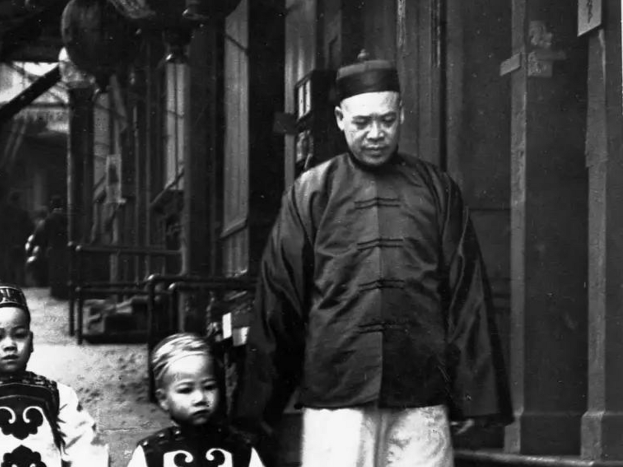 View of man and two children walking down street in the San Francisco Chinatown