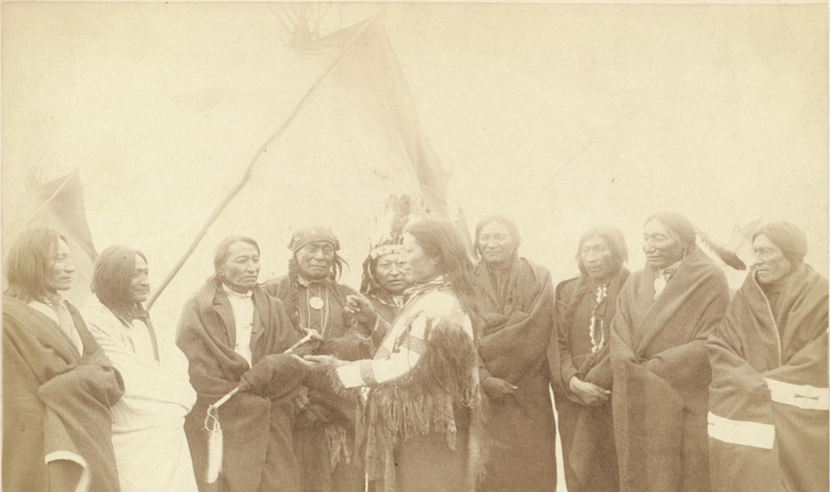 A group photograph of Lakota chiefs standing in front of tipi.