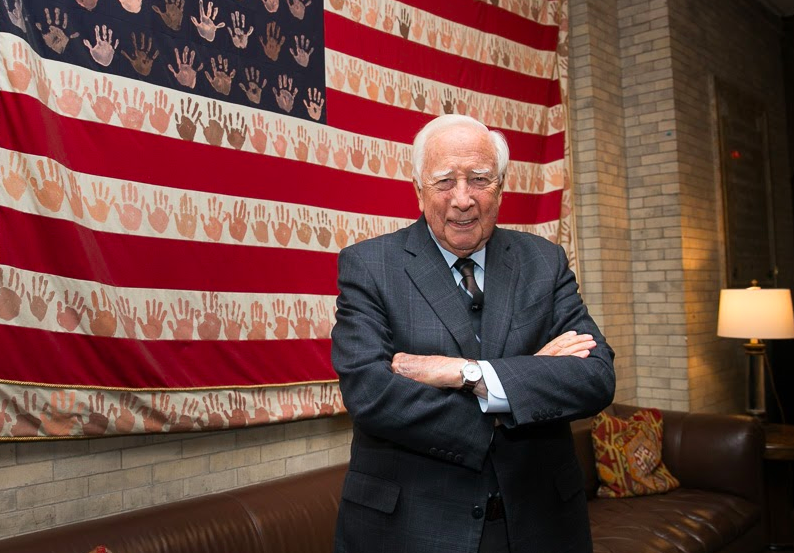 David McCullough in front of a student-painted American flag at Trinity School..