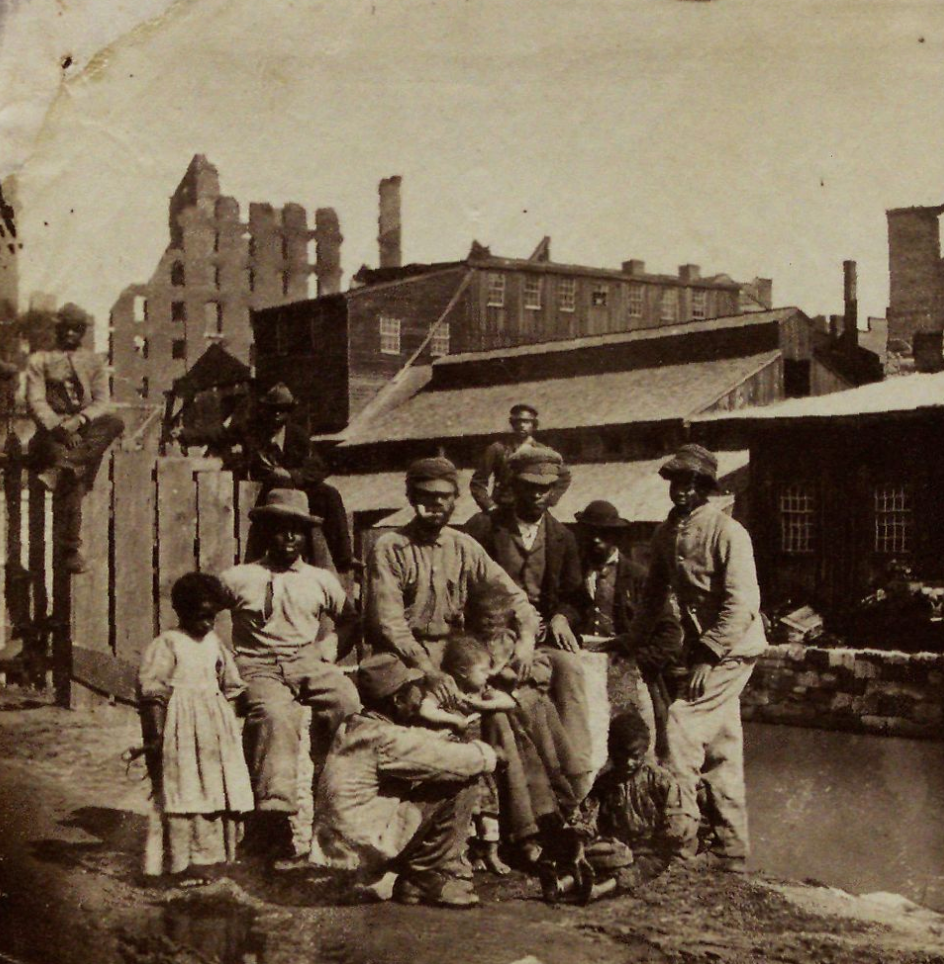 Origins of the Civil War (Civil War Era photo of a black family standing in front of crumbling city buildings)