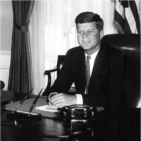 The Kennedy Presidency (Photo of President Kennedy sitting at his desk in the Oval Office)