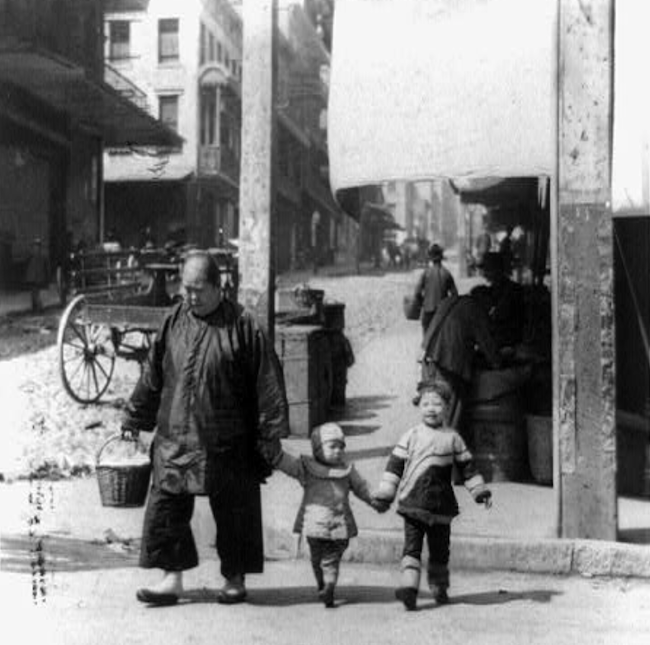 Man with two children in Asian clothing in horse-and-buggy era