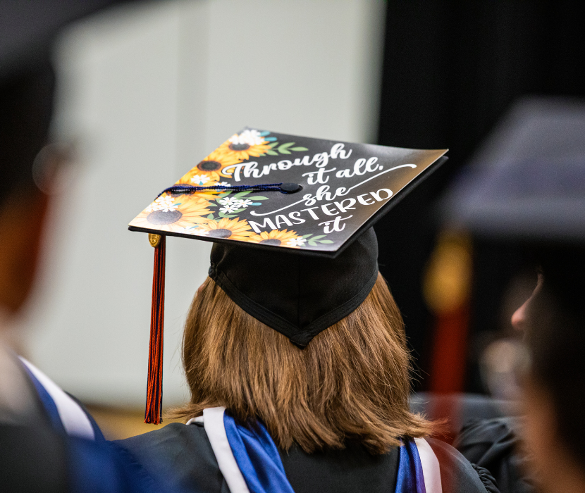 Student at the inaugural Gettysburg College-Gilder Lehrman MA graduation with cap saying 'Through it all she Mastered it'