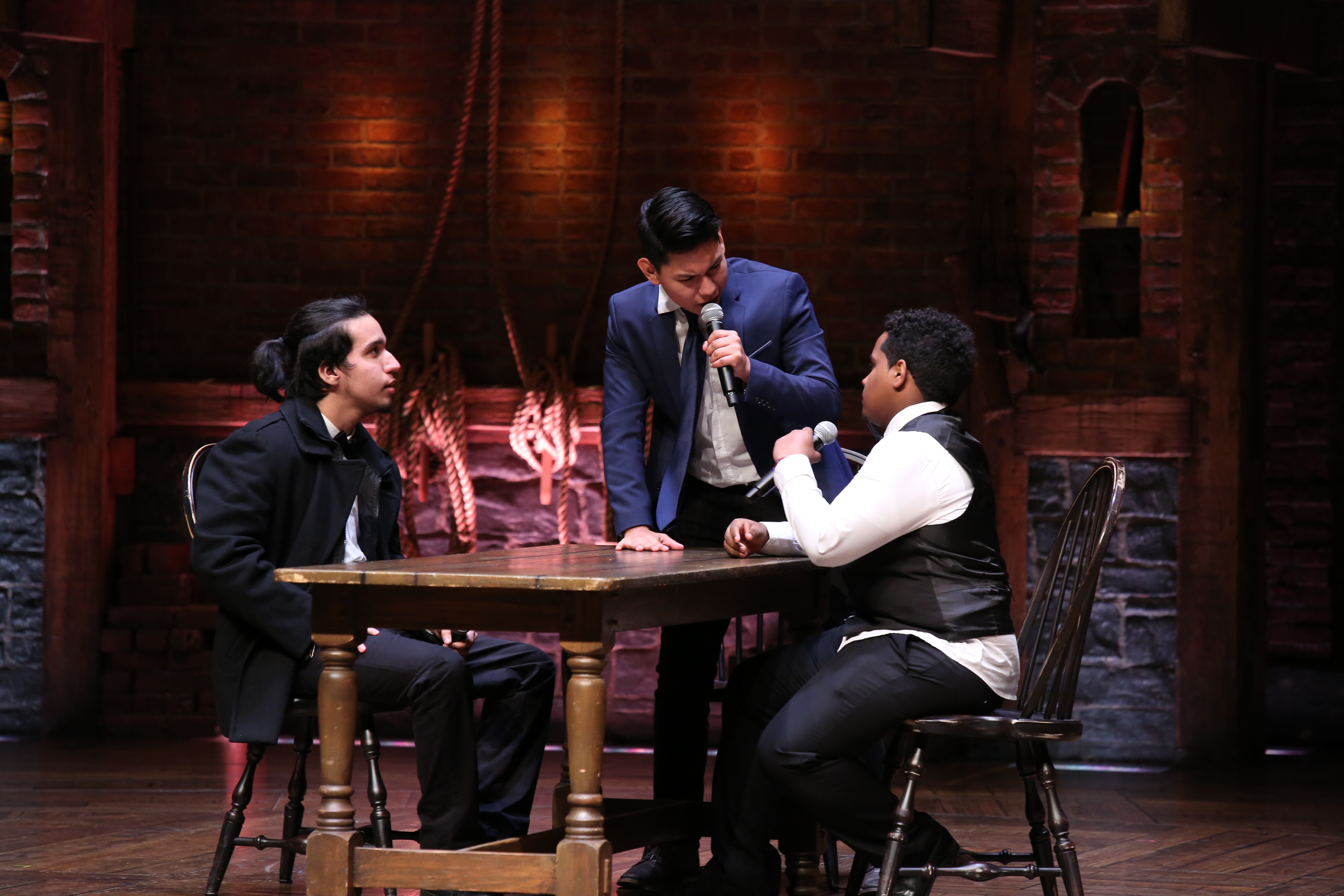 Three students on the Hamilton Musical set performing as part of the EduHam program.