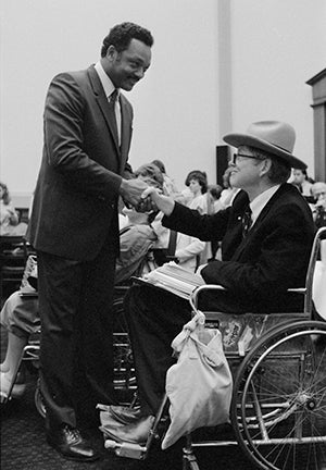 The Rev. Jesse Jackson greets Justin Dart Jr., a disability rights advocate, Washington DC, July 17, 1989. Photograph by R. Michael Jenkins. (Library of Congress Prints and Photographs Division)