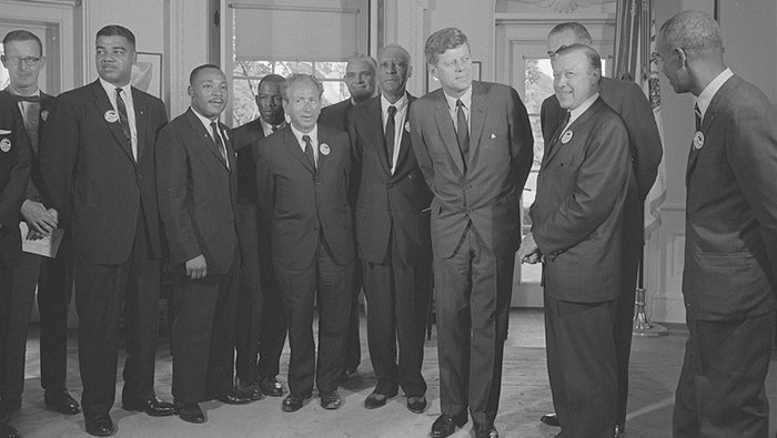 Civil rights leaders meet with President John F. Kennedy in the oval office of the White House after the March on Washington, August 28, 1963 [Photograph shows (left to right): Mathew Ahmann (National Catholic Conference for Interracial Justice); Whitney Young (National Urban League); Martin Luther King Jr. (SCLC); John Lewis (SNCC); Rabbi Joachim Prinz (American Jewish Congress); Reverend Eugene Carson Blake (United Presbyterian Church); A. Philip Randolph; President John F. Kennedy; Walter Reuther (labor leader), with Vice President Lyndon Johnson partially visible behind him; and Roy Wilkins (NAACP).] (Library of Congress)