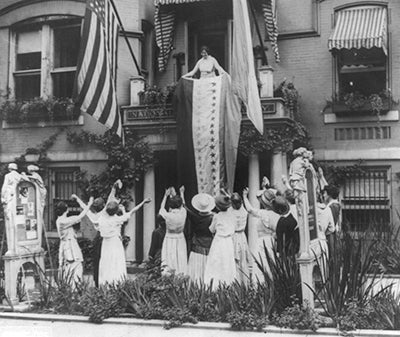 "When Tennessee, the 36th state, ratified [the Nineteenth Amendment] on Aug 18, 1920, Alice Paul, national chairman of the Woman's Party, unfurled the ratification banner from suffrage headquarters, Washington, DC," photograph by Harris & Ewing, 1920 (Library of Congress)
