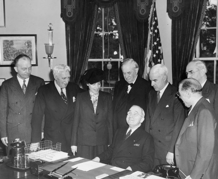 President Harry S. Truman (sitting) meets in the Oval Office of the White House with the American Delegation to the United Nations Conference in San Francisco, California, April 17, 1945. [Delegation members from left to right: Commander Harold Stassen, Representative Charles Eaton of New Jersey, Barnard College Dean Mrs. Virginia Gildersleeve, Senator Tom Connally of Texas, Secretary of State Edward Stettinius, Senator Arthur Vandenberg of Michigan, and Representative Sol Bloom of New York.] (Harry S. Truman Library & Museum)
