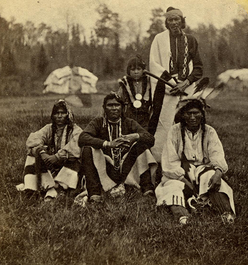 A photograph of a group of Ojibwe (Anishinaabeg) men, ca. 1869; "Scene at Indian Payment.--Odanah, Wis.: Lake Superior Scenery, North Shore," printed by Whitney & Zimmerman, St. Paul, MN, ca. 1869 (© The Trustees of the British Museum, CC BY-NC-SA 4.0)