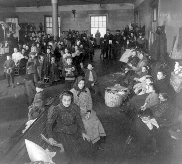Newly arrived immigrants in waiting room at Ellis Island, New York, 1907 (Library of Congress)