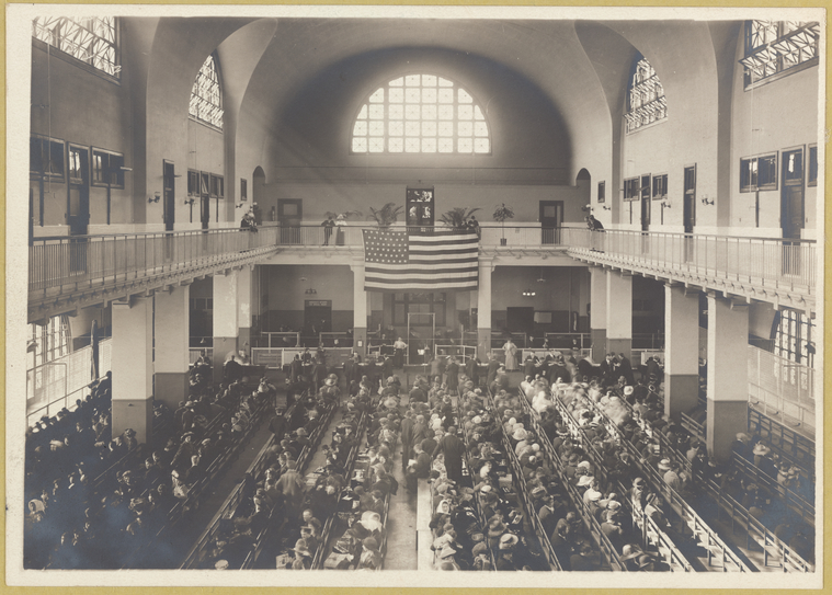 Immigrants seated on long benches, Main Hall, US Immigration Station, Ellis Island, New York, ca. 1907−1912 (New York Public Library).