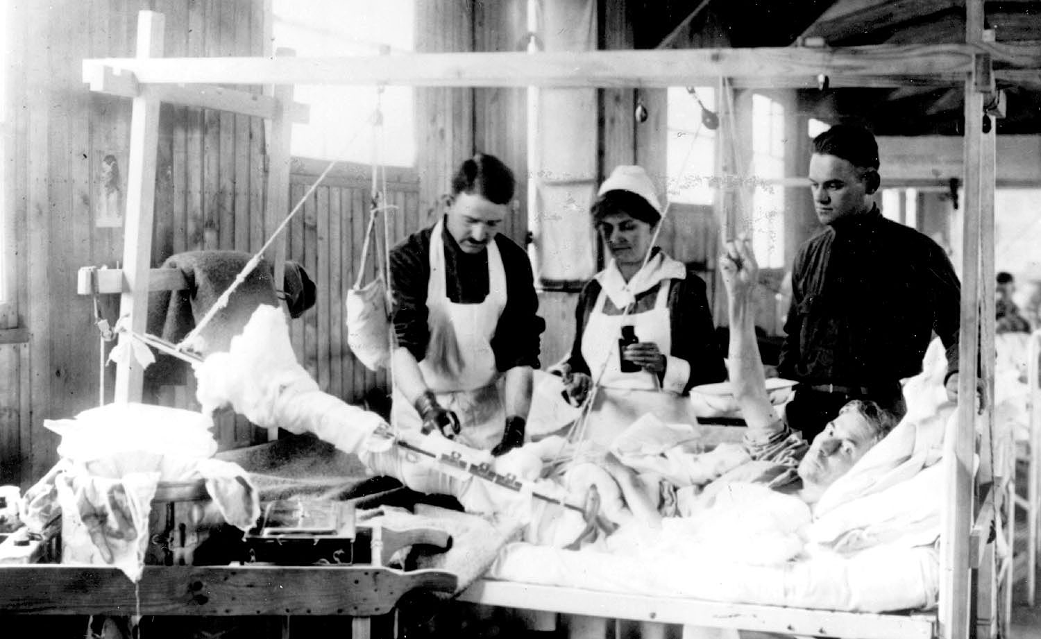 An Army nurse assists with treatment of a patient during World War I.