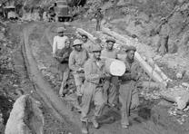 Army engineer troops haul logs down a road while building the Alcan Highway, ca. 1942. (US Army Photo courtesy of Office of History, HQ, US Army Corps of Engineers) Army engineers build the Alcan Highway, ca. 1942. (US Army Corps of Engineers)