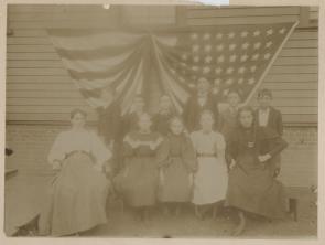 Photo of Miss Annie E. Cole (left, seated) and schoolchildren from PS #5, Huguen