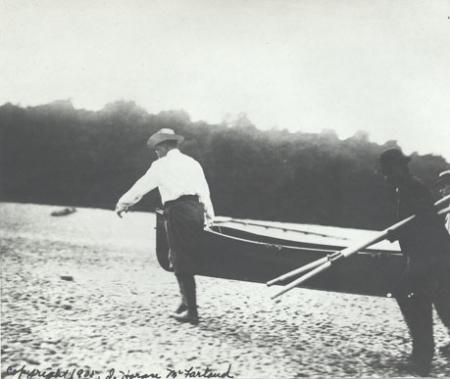 Theodore Roosevelt carrying a rowboat on his Cold Spring Harbor Beach with a Sagamore Hill staff person, June 1905. Theodore Roosevelt carrying a rowboat on his Cold Spring Harbor Beach with a Sag