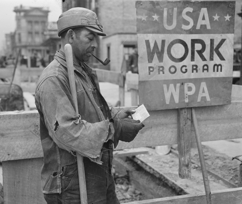 Photo showing WPA worker receiving a paycheck with sign in background "USA Work Program WPA"