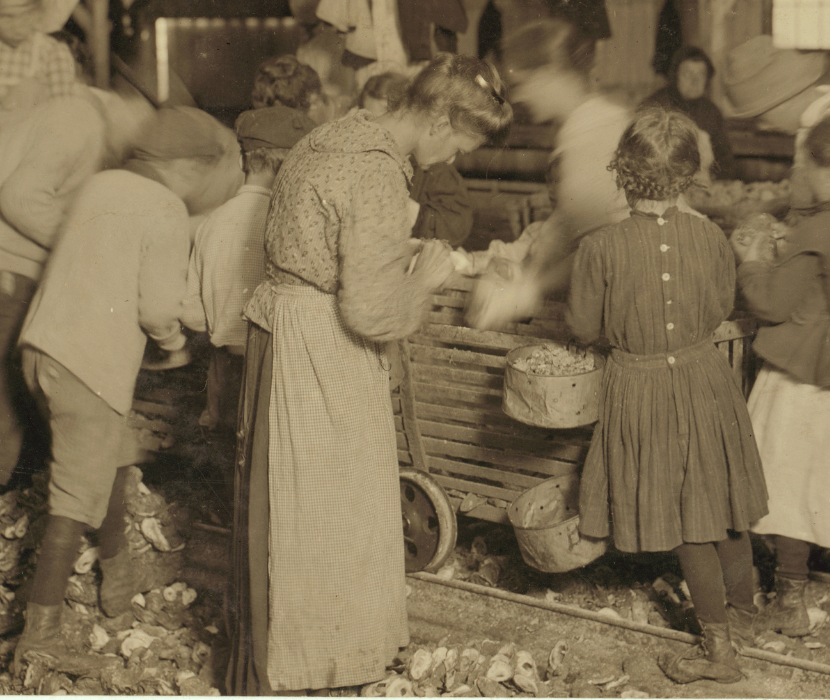 Detail from black and white photograph showing children five to eight years old shucking oysters at the Barataria Canning Co.