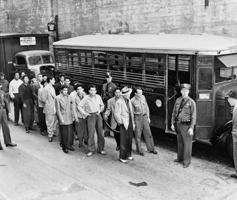 1943 photo of Zoot Suiters lined up by bus on their way to court