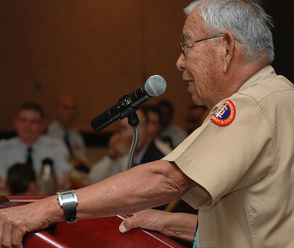 Photograph of Joe Morris Sr. giving a talk at a lectern displaying the NASA logo.