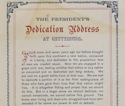 View of title and first full paragraph of semi-ornate printed version of Abraham Lincoln's Gettysburg Address, featuring decorative border and selective use of red ink in the text.