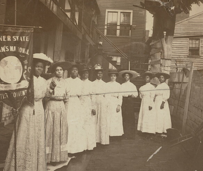 Nannie Helen Burroughs holding banner. African-American women posed, standing, full length, with Nannie Burroughs holding banner reading, "Banner State Woman's National Baptist Convention."