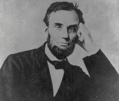 A black-and-white photograph of President Abraham Lincoln, seated, with his head resting on his upraised left hand
