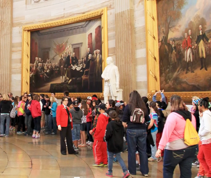Throngs of people in the capitol rotunda, gathered around a statue