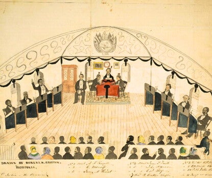 Watercolor painting of a room with Black men dressed in formal black coats, white waistcoats and shirts, and black ties, sitting at desks along the left and right walls; one is standing to speak with his hand raised; a presiding officer flanked by three other officials, two at left, one at right, sits at a desk covered in a red and black cloth on a raised platform at the front of the room; Black men and women sit on benches observing in the foreground. The names of some participants are written below the im