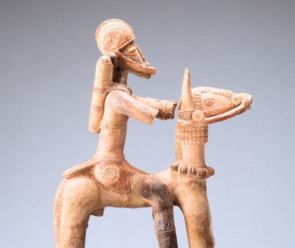 Stylized clay sculpture of an armored soldier on a horse