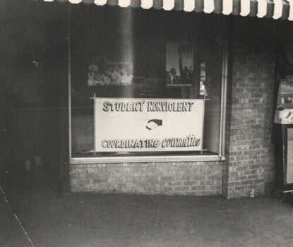 A storefront window with a sign for the Student Nonviolent Coordinating Committee.