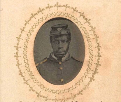 A photograph of a Black Civil War Union soldier in uniform in a rounded rectangular frame.