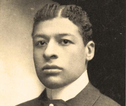 Bert Williams, a Black man, wearing a black coat and white collar.