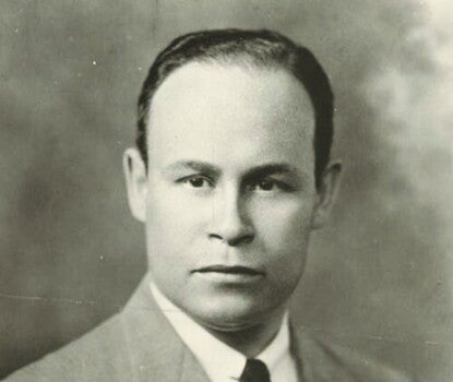 A black-and-white headshot of Charles Drew, a light-skinned Black man, wearing a gray suit jacket (and a white pocket square in his left breast pocket), a white shirt, and a dark necktie.