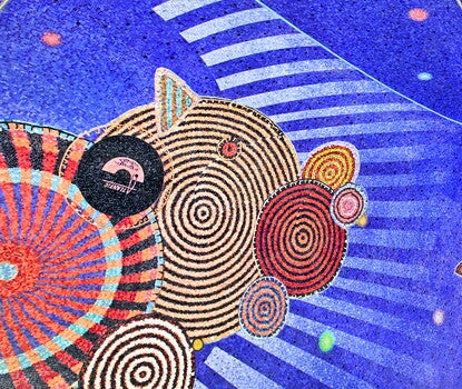 A panoramic image of a mosaic featuring spirals and circles on a blue field.