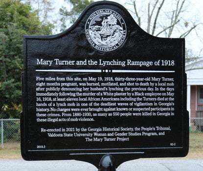 A black historical marker with white text and the seal of the Georgia Historical Society at top.