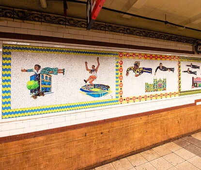 A white tile mosaic mural of several Black people airborne above buildings.