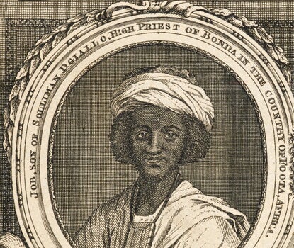 A portrait of a Black man with long black hair wearing a white turban, white robe, and necklace.