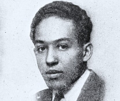 Langston Hughes, a Black man, wearing a dark suit, dark tie, and white shirt.