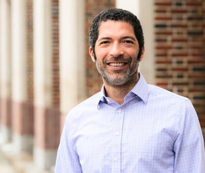 Matthew Delmont smiling while wearing a light blue checked shirt.