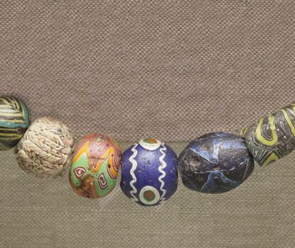 A string of 8 multicolored glass beads