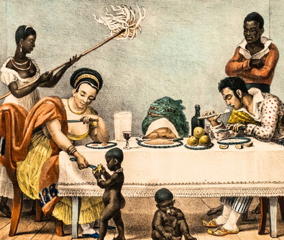 A White woman in a yellow dress and dark orange cape and a White man in a white and red shirt and blue and white striped pants, eating at a table. Behind them are two Black people: a woman in a white dress fanning the two seated White people, and a man, wearing a white collared shirt and orange sweater, arms crossed behind the seated White man. In front of the table are two naked Black children, one of whom is being fed by the White woman.