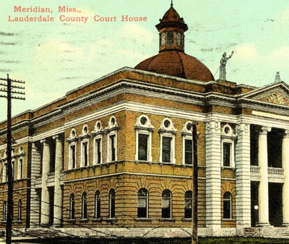 A color postcard depicting a brick courthouse with a cupola and entrance pediment in Meridian, Mississippi.