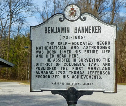 A white historical marker with black text for Benjamin Banneker's birthplace and home.