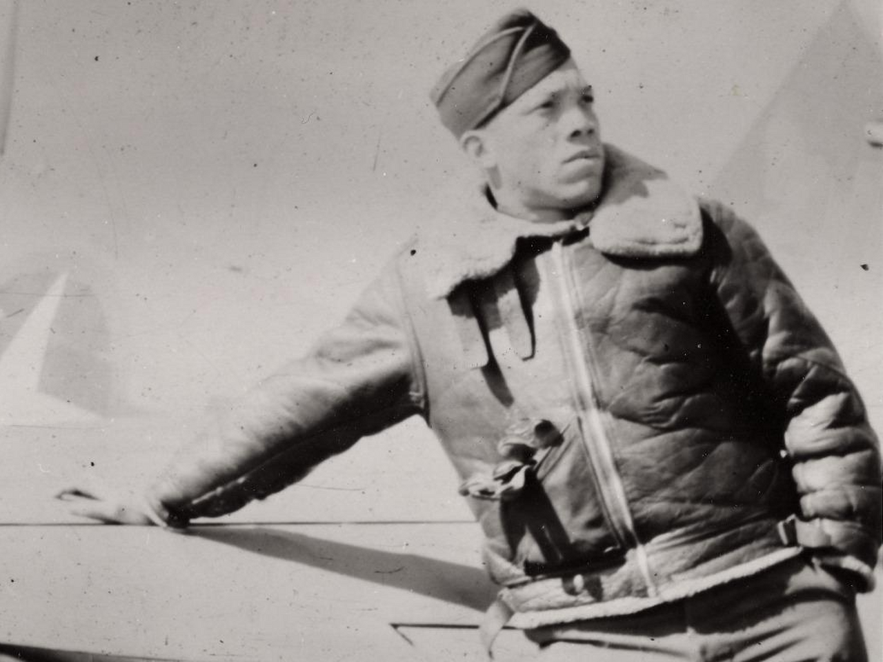 John Rogers Sr in uniform, leaning against an airplane