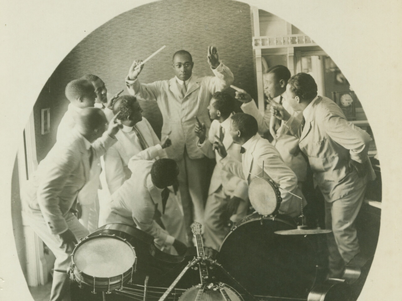 Photograph of James Reese with his band. He is shown conducting as the band members point at him.