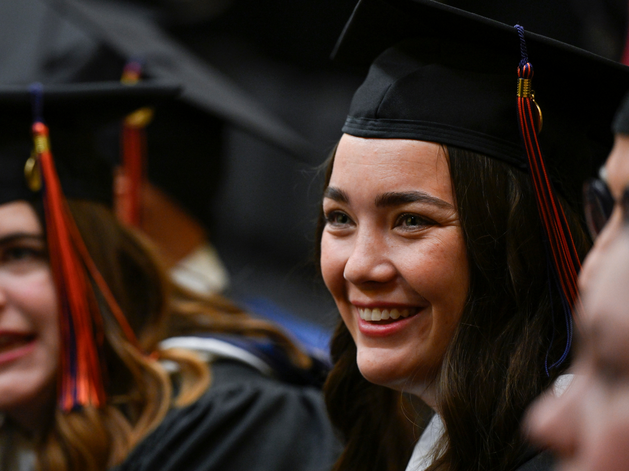 View of two graduating MA program students in cap and gown (one in the foreground, the other in the background) at the inaugural Gettysburg Commencement Ceremony