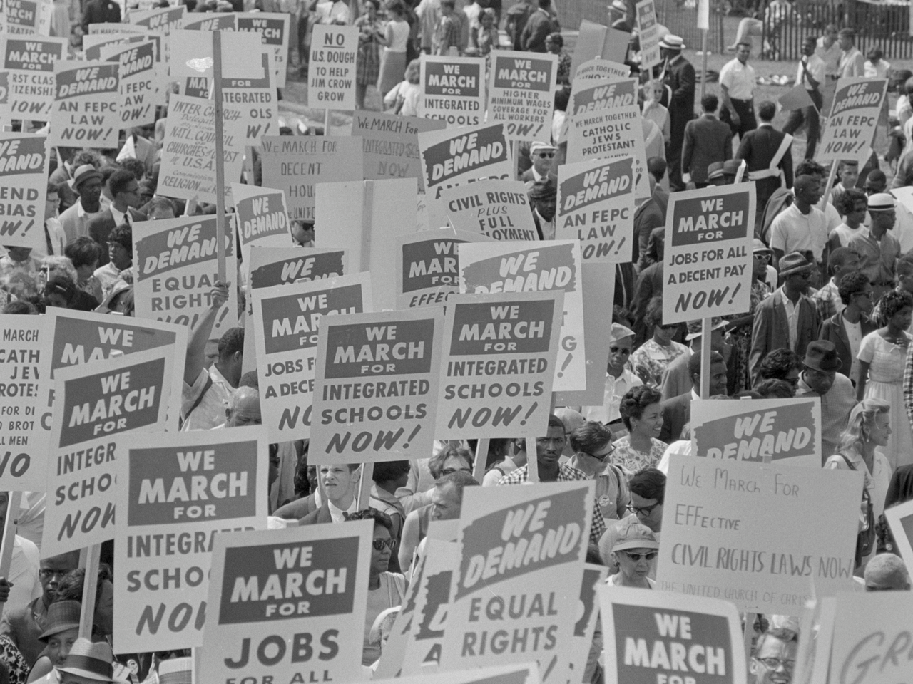 Black and white photograph showing the protest signs at the 1963 march on Washington, D.C. 