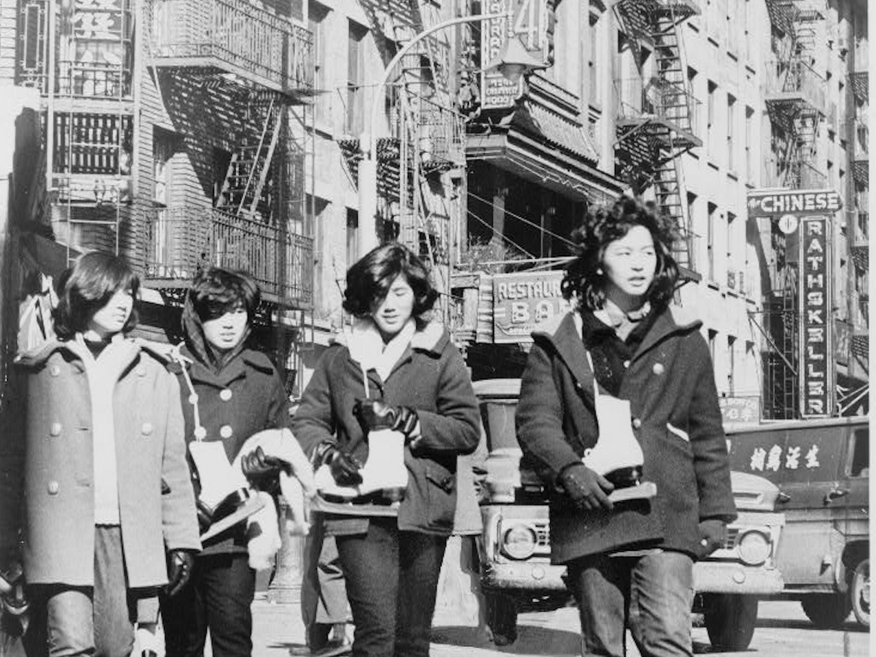 Four Chinese American girls carrying ice skates in Chinatown NYC