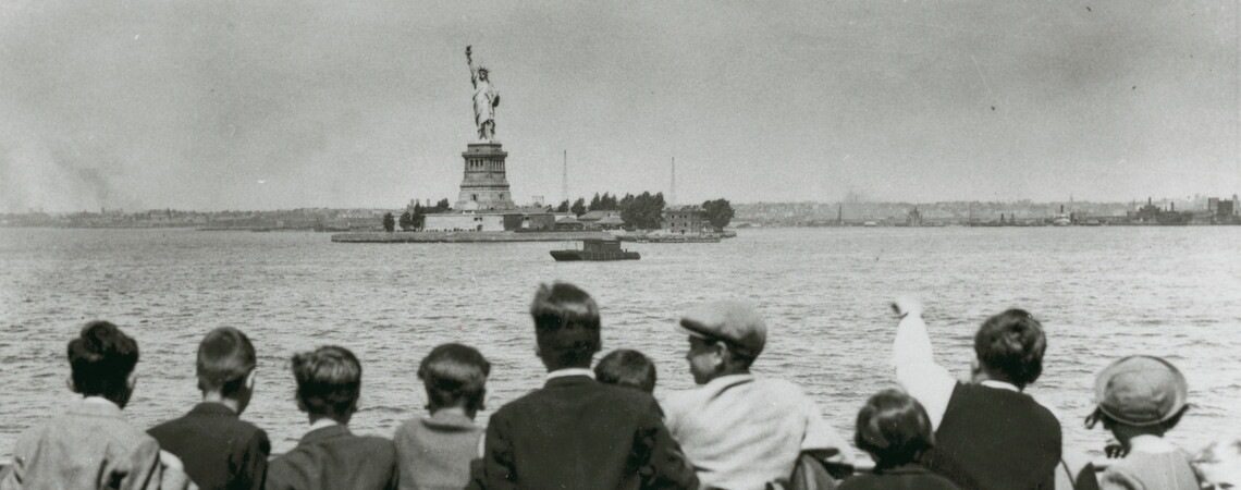 Children aboard the President Harding look at the Statue of Liberty as they pull into New York harbor. They were brought to the United States by Gilbert and Eleanor Kraus.