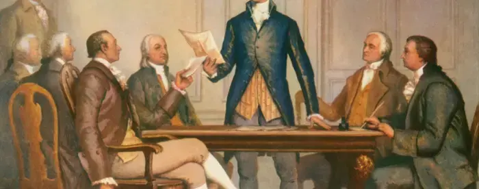 Alexander Hamiton reading a document to a group of men at a table
